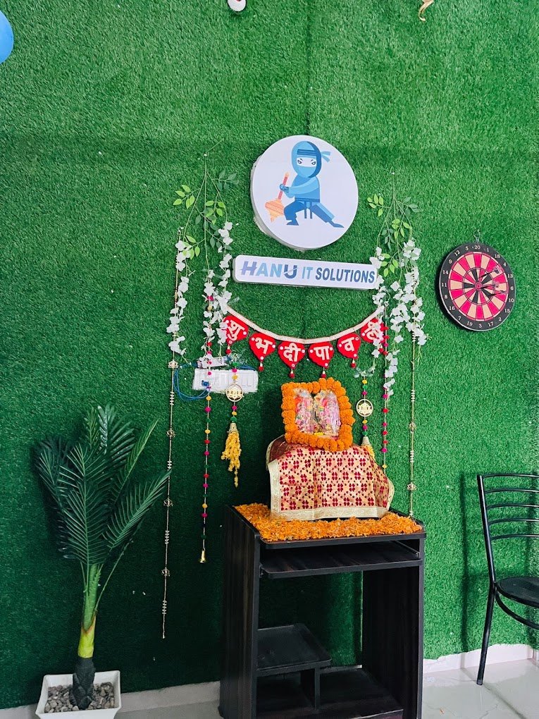 Festive decoration area with lakshmi idol and Hanu IT Solutions logo on green wall background-HanuiT solutions